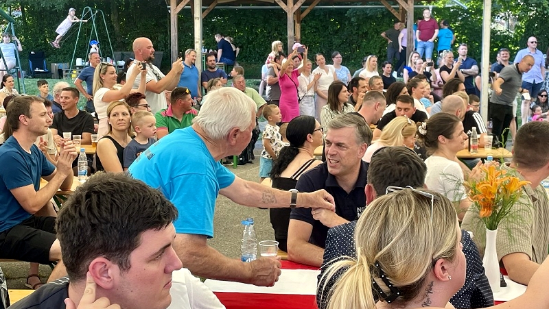 Na fotografiji je župan Gregor Macedoni na prazniku Krajevne skupnosti Otočec med pogovorom s krajanom Na Otočcu veselo ob prazniku krajevne skupnosti