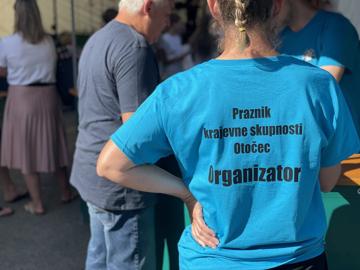 Na fotografiji je majica z natisom Praznik Krajevne skupnosti Otočec 2026 Na fotografiji je majica z natisom Praznik Krajevne skupnosti Otočec 2026