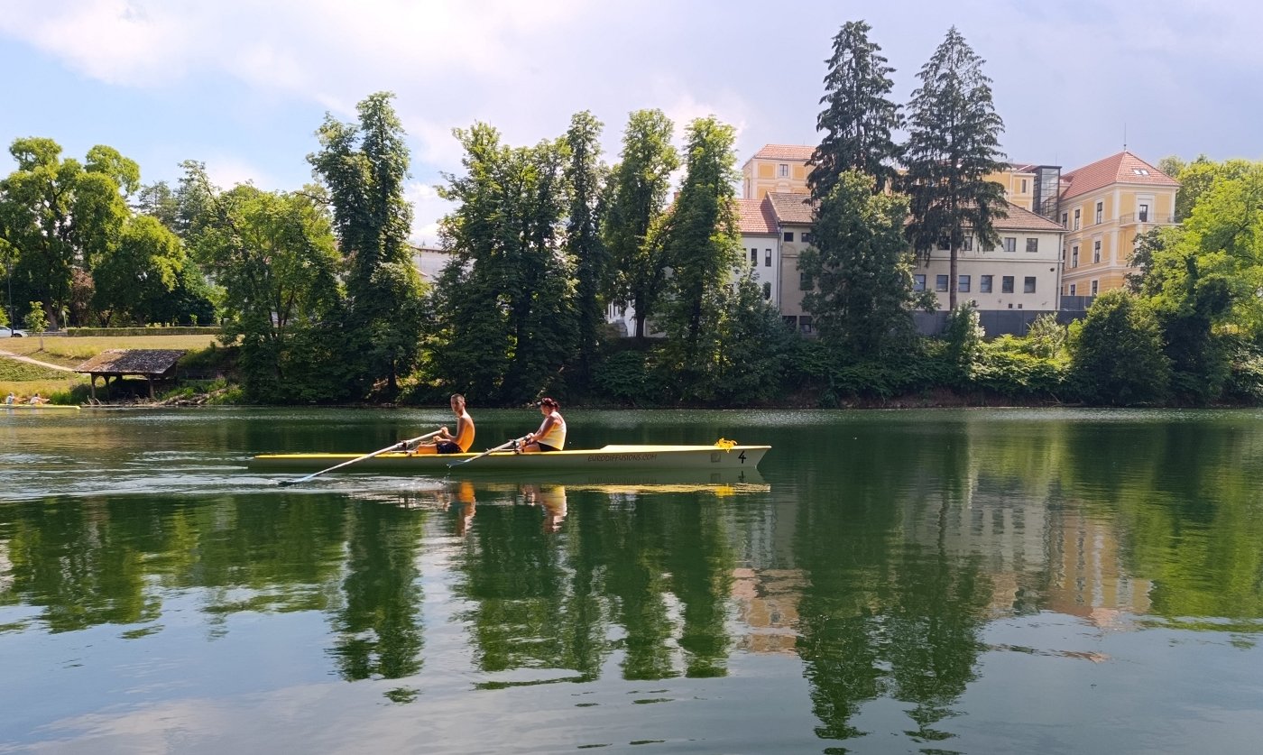 Na fotografiji sta veslača med veslanjem na Krki Na fotografiji sta veslača med veslanjem na Krki